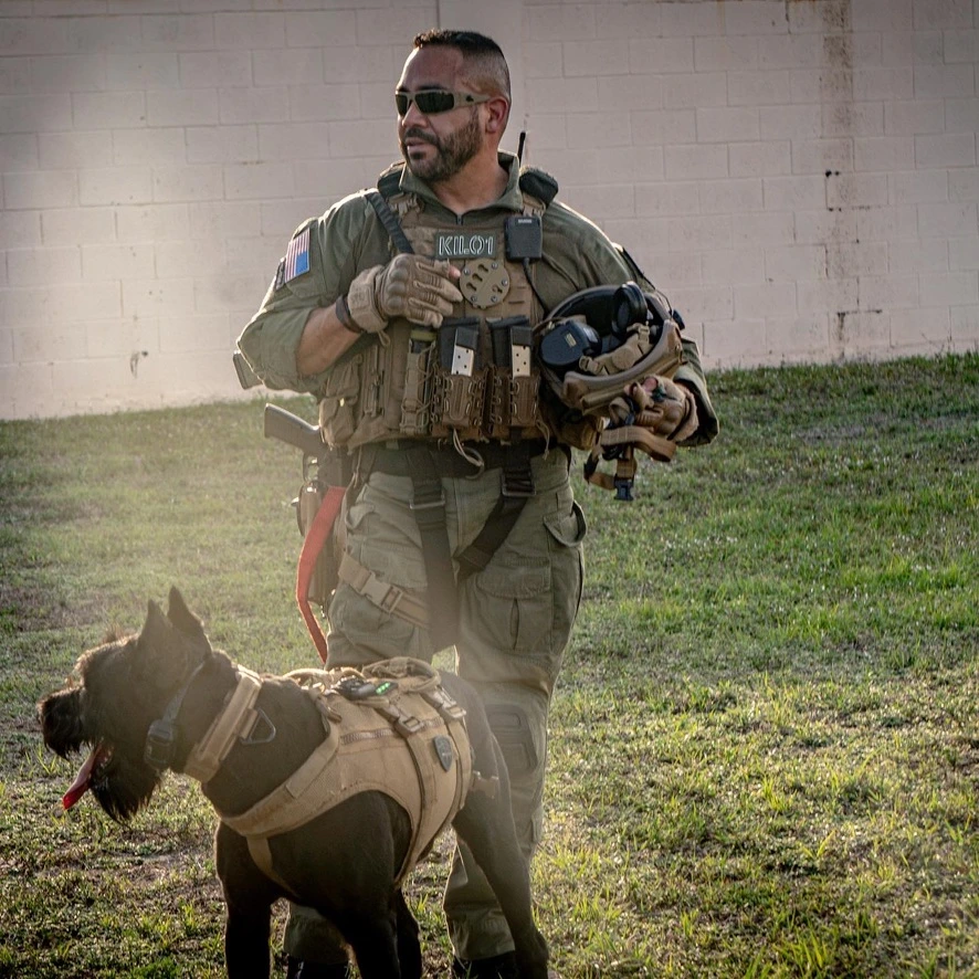 Joseph Garcia in operational equipment beside a Giant Schnauzer